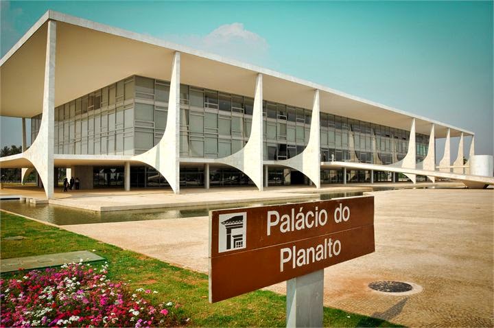 Fachada do Palácio do Planalto em dia de céu claro, com a placa de identificação em primeiro plano.