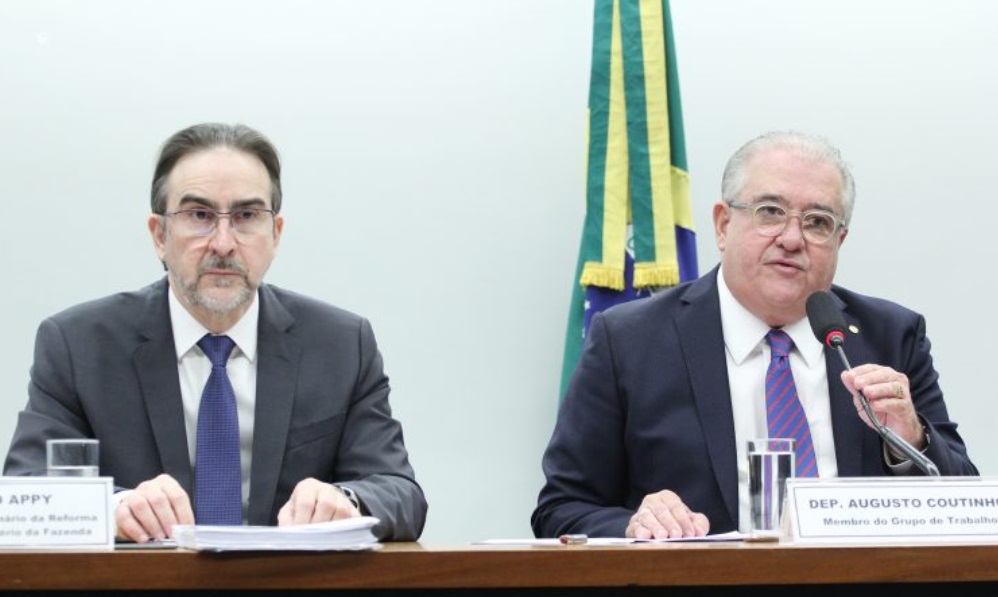 Bernard Appy e o deputado Augusto Coutinho lado a lado à mesa da reunião do grupo de trabalho da reforma tributária.